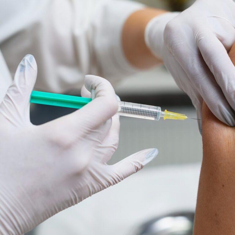 Doctor apply syringe needle in female hand, health vaccination and medical treatment concept