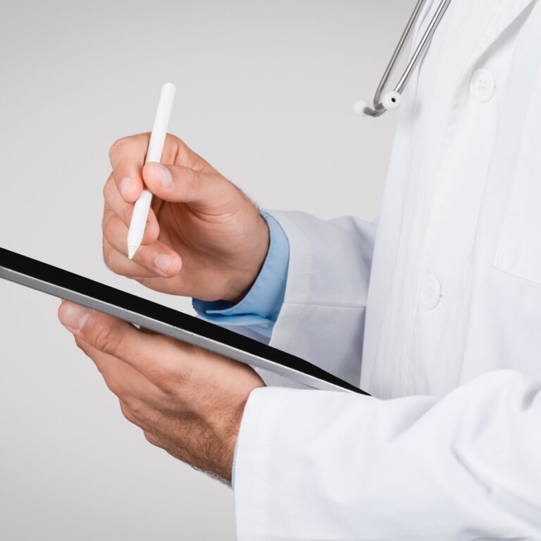 Close-up of medical professional using a stylus pen on a digital tablet, symbolizing modern digital healthcare documentation and telemedicine