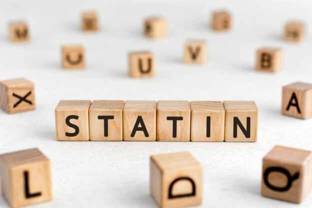 Statin - words from wooden blocks with letters, cholesterol level reduces drugs statin concept, white background